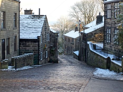 the historic yorkshire village of heptonstall in winter with snow covered roofs and street