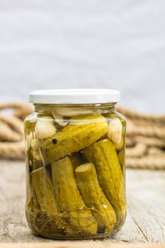 Close up of glass jar with pickles isolated. Preserved food concept, canned vegetables isolated in a rustic composition.