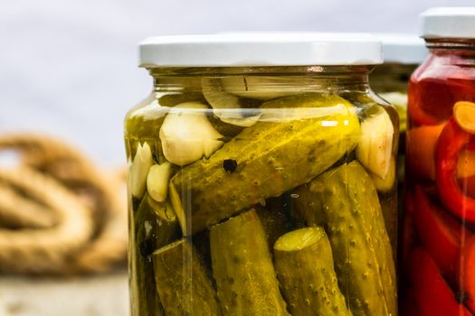 Close up of glass jar with pickles isolated. Preserved food concept, canned vegetables isolated in a rustic composition.