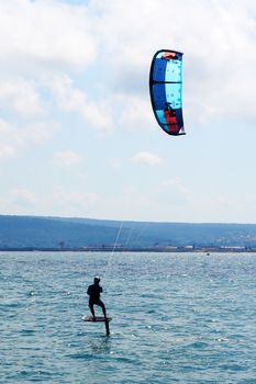 Varna, Bulgaria - July, 19, 2020: a man is kiting the sea on a sunny windy day