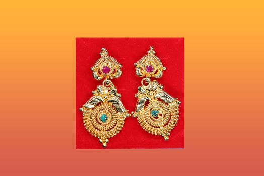 Beautifully designed earrings and a green and red colored stonework view, gold jewels