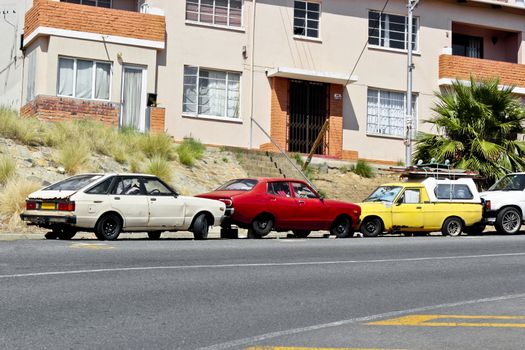 Broken car wrecks in Cape Town, South Africa. Cars, apartment blocks and city life.