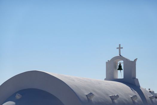 Close up of bell, white church in Oia Santorini, Greece.