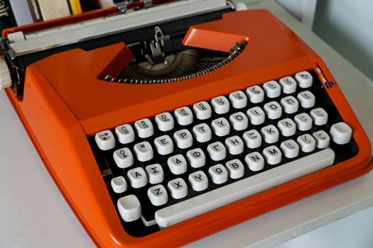 Red vintage Typewrite Machine with greek alphabet on white table.