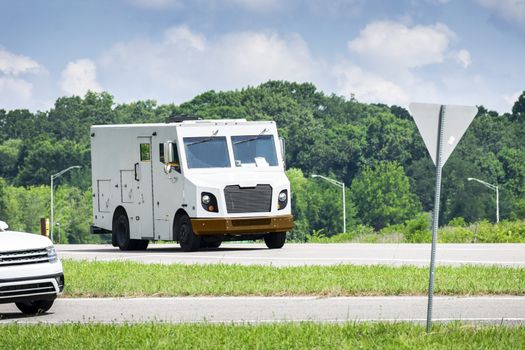 Horizontal shot of an unmarked armored car in traffic.