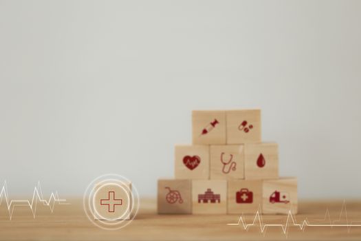 Healthcare concept about of health and medical insurance, arranging wood block stacking with icon healthcare medical on table wooden background.