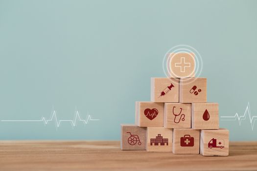 Healthcare concept about of health and medical insurance, arranging wood block stacking with icon healthcare medical on table wooden background.