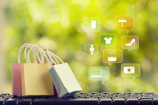 Online marketing/payment concept: shopping bags with smartphones on computer keyboard, icon online shopping and social media networking. depicts consumer buy goods, products and service from internet