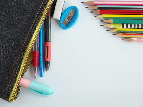 The top view of  stationery in school bags and pencils arranged on a white background.