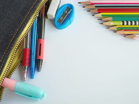 The top view of  stationery in school bags and pencils arranged on a white background.