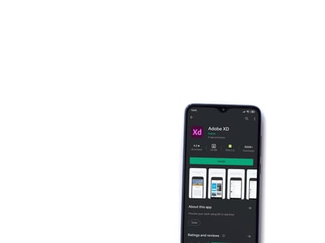 Lod, Israel - July 8, 2020: Adobe XD app play store page on the display of a black mobile smartphone isolated on white background. Top view flat lay with copy space. 