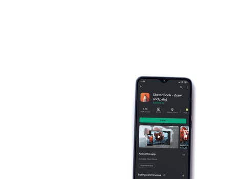 Lod, Israel - July 8, 2020: Autodesk SketchBook - draw and paint app play store page on the display of a black mobile smartphone isolated on white background. Top view flat lay with copy space.