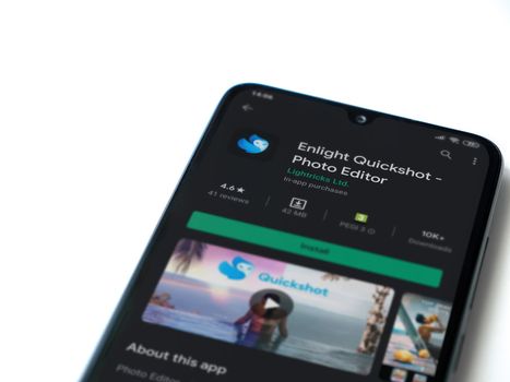 Lod, Israel - July 8, 2020: Enlight Quickshot app play store page on the display of a black mobile smartphone isolated on white background. Top view flat lay with copy space.