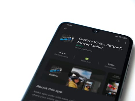 Lod, Israel - July 8, 2020: GoPro - Video Editor & Movie Maker app play store page on the display of a black mobile smartphone isolated on white background. Top view flat lay with copy space.