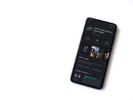 Lod, Israel - July 8, 2020: GoPro - Video Editor & Movie Maker app play store page on the display of a black mobile smartphone isolated on white background. Top view flat lay with copy space.