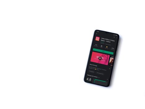 Lod, Israel - July 8, 2020: InShot - Video Editor & Movie Maker app play store page on the display of a black mobile smartphone isolated on white background. Top view flat lay with copy space.