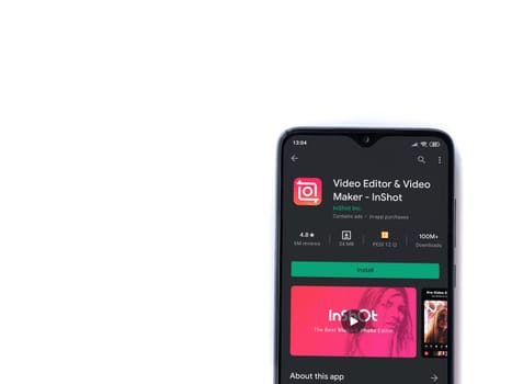 Lod, Israel - July 8, 2020: InShot - Video Editor & Movie Maker app play store page on the display of a black mobile smartphone isolated on white background. Top view flat lay with copy space.