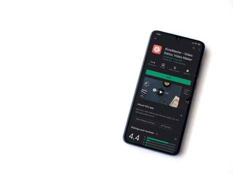 Lod, Israel - July 8, 2020: KineMaster - Video Editor & Movie Maker app play store page on the display of a black mobile smartphone isolated on white background. Top view flat lay with copy space.