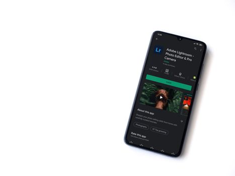Lod, Israel - July 8, 2020: Adobe Lightroom - Photo Editor & Pro Camera app play store page on the display of a black mobile smartphone isolated on white background. Top view flat lay with copy space.