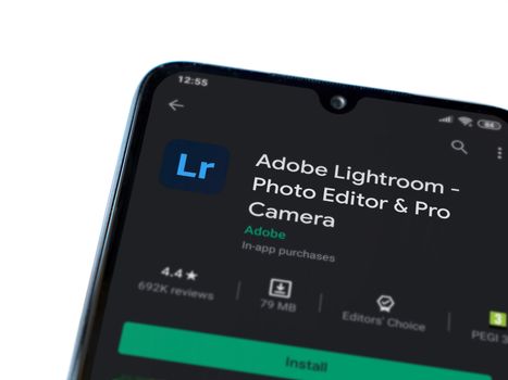 Lod, Israel - July 8, 2020: Adobe Lightroom - Photo Editor & Pro Camera app play store page on the display of a black mobile smartphone isolated on white background. Top view flat lay with copy space.
