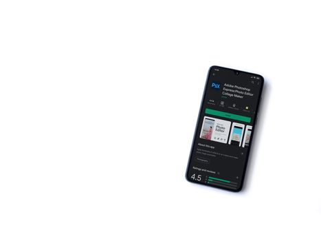 Lod, Israel - July 8, 2020: Adobe Photoshop Express Photo Editor app play store page on the display of a black mobile smartphone isolated on white background. Top view flat lay with copy space.