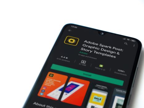 Lod, Israel - July 8, 2020: Adobe Spark Post - Graphic Design & Story Templates app play store page on the display of a black mobile smartphone on white background. Top view flat lay with copy space. 