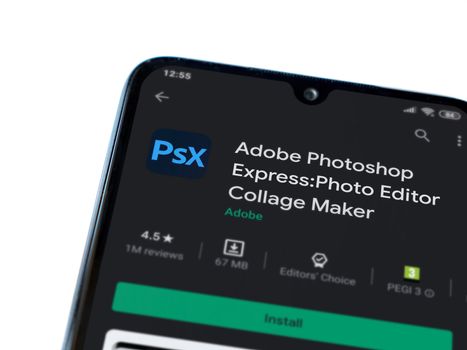 Lod, Israel - July 8, 2020: Adobe Photoshop Express Photo Editor app play store page on the display of a black mobile smartphone isolated on white background. Top view flat lay with copy space.