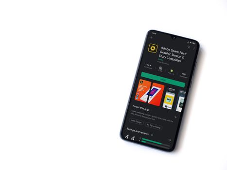Lod, Israel - July 8, 2020: Adobe Spark Post - Graphic Design & Story Templates app play store page on the display of a black mobile smartphone on white background. Top view flat lay with copy space. 