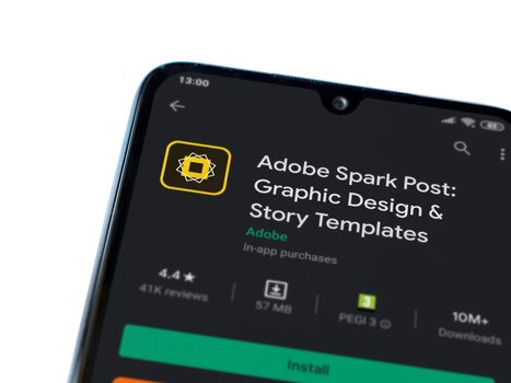 Lod, Israel - July 8, 2020: Adobe Spark Post - Graphic Design & Story Templates app play store page on the display of a black mobile smartphone on white background. Top view flat lay with copy space. 