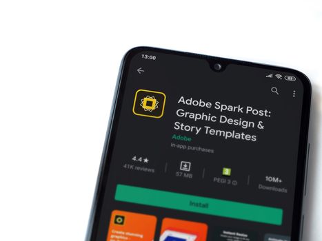 Lod, Israel - July 8, 2020: Adobe Spark Post - Graphic Design & Story Templates app play store page on the display of a black mobile smartphone on white background. Top view flat lay with copy space. 
