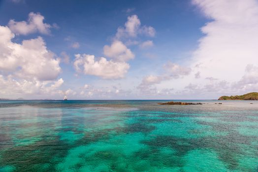 Wide-angle shot overlooking the crystal clear waters of the South Pacific off Fiji. A cruise ship is on the horizon.