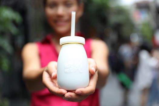 Traditional Beijing yogurt. Typical local street food of China, bottle of dairy drink. Travel lifestyle woman showing chinese dairy product.