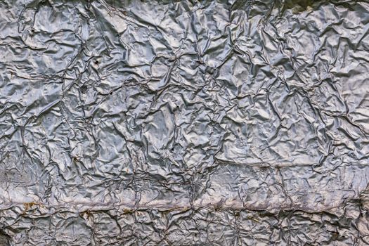 crumpled thick aluminium foil wall insulation surface texture and background.