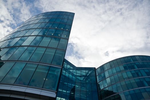 Modern glass and steel office buildings with cloudy sky in background