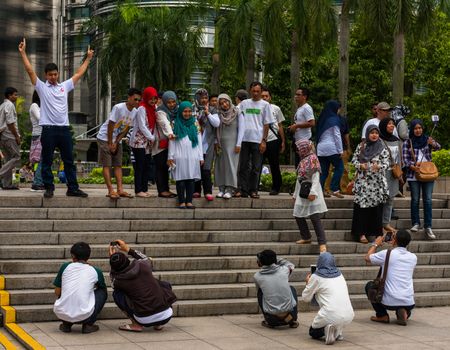 Kuala Lumpur, Malaysia -- March 3, 2106. Groups of tourists pose for photos in Kuala Lumpur