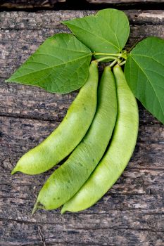 Raw green beans on wood background. Closeup.