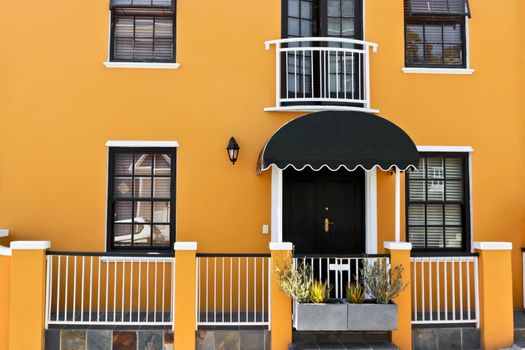 Beautiful African orange house with windows and door texture in Bo-Kaap, Schotsche Kloof.