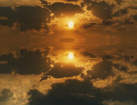 Cloudy sunset reflected in calm water surface