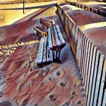 Modern art. Benches on a sand near the fence.