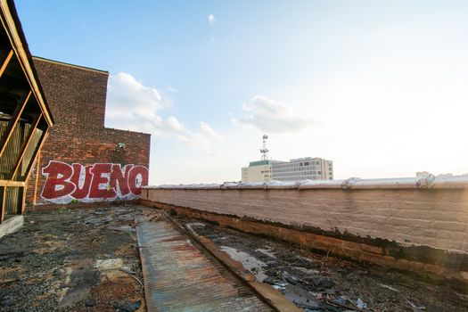 A Rooftop View on top of an Abandoned Building With a Graffiti Tag That Says Bueno