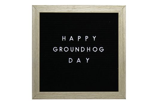 A Black Sign With a Birch Frame That Says Happy Groundhog Day in White Letters on a Pure White Background