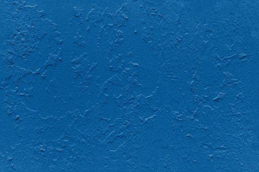 seamless texture of flat thick painted in classic blue color surface under direct sunlight - new paint over fragments of old peeled one