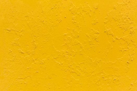 seamless texture of flat thick painted yellow surface under direct sunlight - new paint over fragments of old peeled one