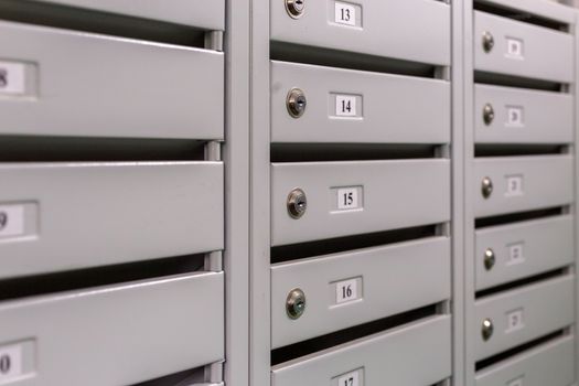 gray mailboxes on the landing of russian condominium - close-up view with selective focus and linear perspective