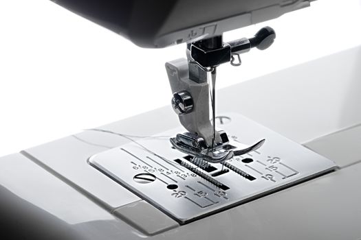 1 - Elevated close up view looking from the left hand side of the working area of a sewing machine.