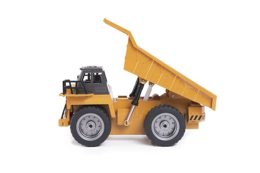 Side view of yellow toy truck dumping on white background.