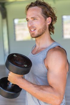 Man lifting dumbbell weights at home gym. Fitness lifestyle.