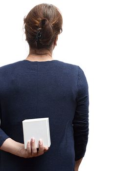 Woman with a gift behind her back on a white background