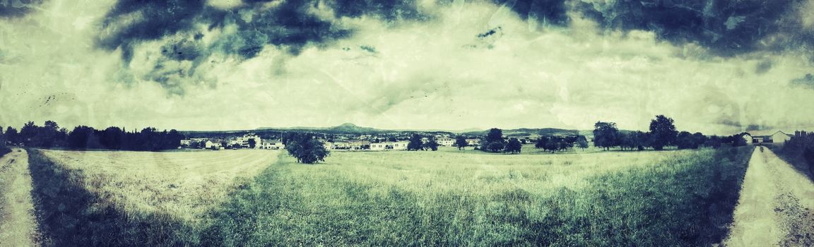 panoramic view over green with dark clouds in vintage look