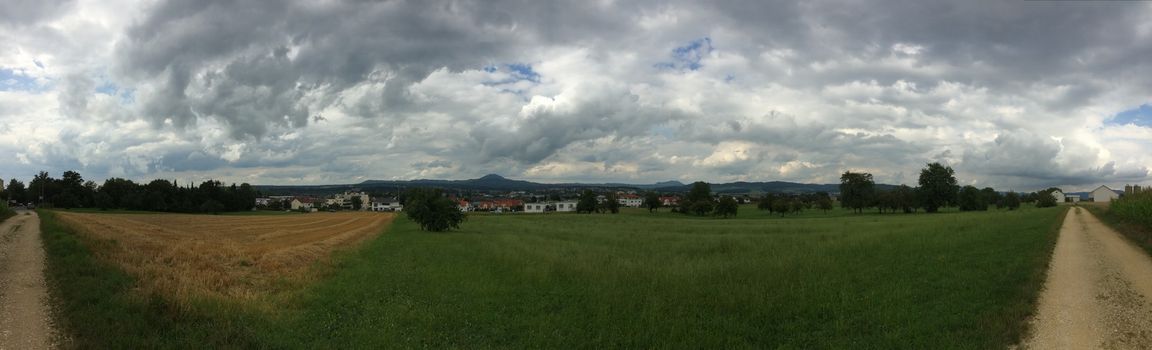 panoramic view over green with dark clouds